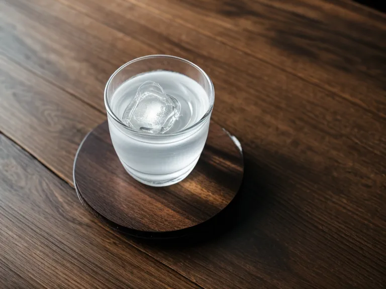 A supplement capsule next to a glass of water and a coding notebook.